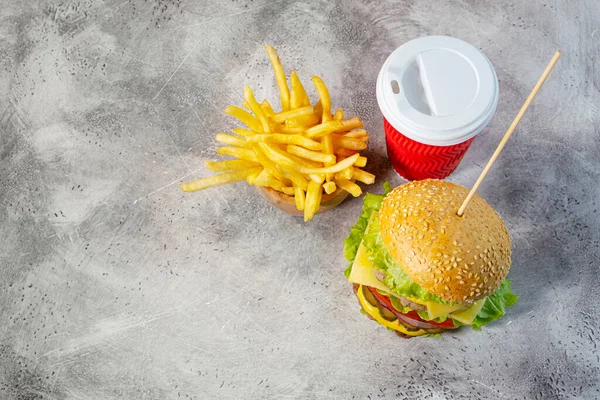 Duble sığır etli büyük hamburger, patates kızartması ve içecek. Üst Manzara. Kopyalama alanı olan arkaplan.