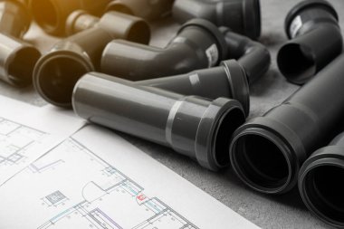Plumbing pipes and project drawing on a concrete background. clipart