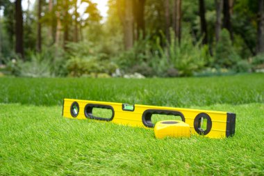 Ölçüm araçları ve bahçede suni çim kurulum arka planı