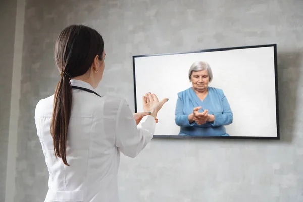 Online medical consultation. Remote medicine during quarantine. Female doctor consults an elderly woman on video conference.