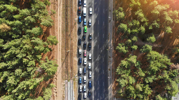 Воздушный. Пробка с большим количеством машин на шоссе между лесом. Вид сверху с беспилотника. 
