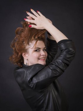 Duygusal esmer bir deri pelerin stüdyoda poz. Karanlık bir arka plan üzerinde izole görüntü.