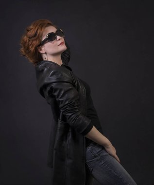 Duygusal esmer bir deri pelerin stüdyoda poz. Karanlık bir arka plan üzerinde izole görüntü.