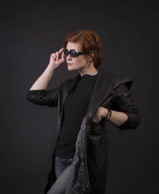 Duygusal esmer bir deri pelerin stüdyoda poz. Karanlık bir arka plan üzerinde izole görüntü.