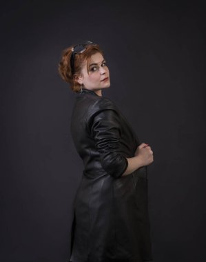 Duygusal esmer bir deri pelerin stüdyoda poz. Karanlık bir arka plan üzerinde izole görüntü.