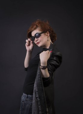 Duygusal esmer bir deri pelerin stüdyoda poz. Karanlık bir arka plan üzerinde izole görüntü.