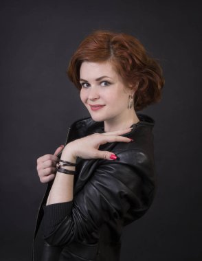 Duygusal esmer bir deri pelerin stüdyoda poz. Karanlık bir arka plan üzerinde izole görüntü.