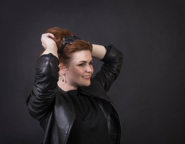 Duygusal esmer bir deri pelerin stüdyoda poz. Karanlık bir arka plan üzerinde izole görüntü.