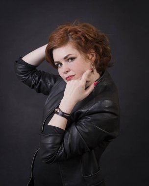 Duygusal esmer bir deri pelerin stüdyoda poz. Karanlık bir arka plan üzerinde izole görüntü.