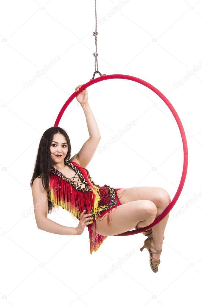 A young girl, with long dark hair, dances and performs in an airy ring in a stage costume. Studio shooting, isolated image.