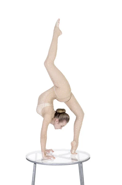 Acrobat jimnastik egzersizleri, rhinestones, elbiseli genç atletik kadın akrobasi pratik yapar. Beyaz bir arka plan üzerinde izole görüntü.