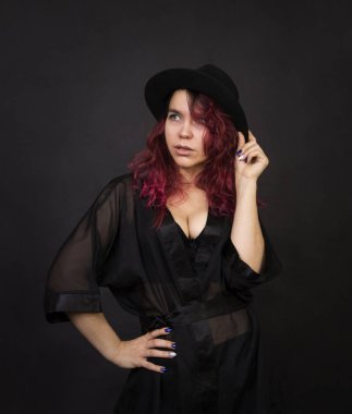 Duygusal bir şapka koyu arka plan Studio.Isolated görüntülerde poz uzun saçlı esmer.