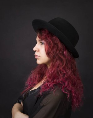 Duygusal bir şapka koyu arka plan Studio.Isolated görüntülerde poz uzun saçlı esmer.