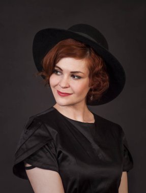 Duygusal esmer Studio şapkalı bir poz. Koyu arka plan üzerinde izole görüntü.