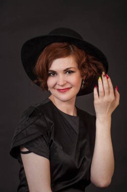 Duygusal esmer Studio şapkalı bir poz. Koyu arka plan üzerinde izole görüntü.