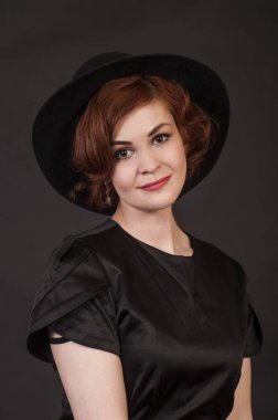 Duygusal esmer Studio şapkalı bir poz. Koyu arka plan üzerinde izole görüntü.