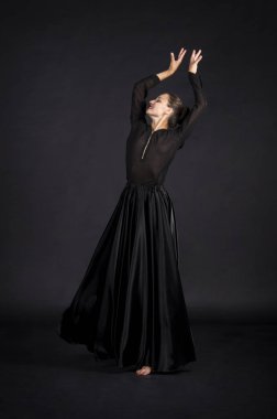 Genç kız siyahlı gülümseyen bir dans eden modern koreografi uygun. Stüdyo koyu arka plan üzerinde izole görüntü vurdu.