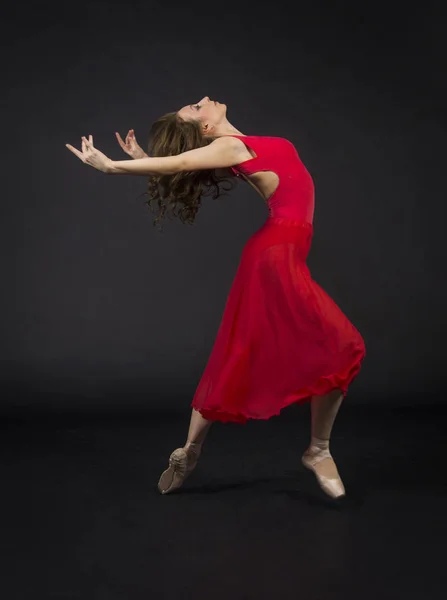 バレエを踊る赤での長い髪を持つ少女 暗い背景にスタジオ撮影 — ストック写真