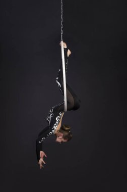 Genç bir kız akrobatik öğeleri hava ringde gerçekleştirir. Stüdyo performansları bir siyah arka plan üzerinde çekim.