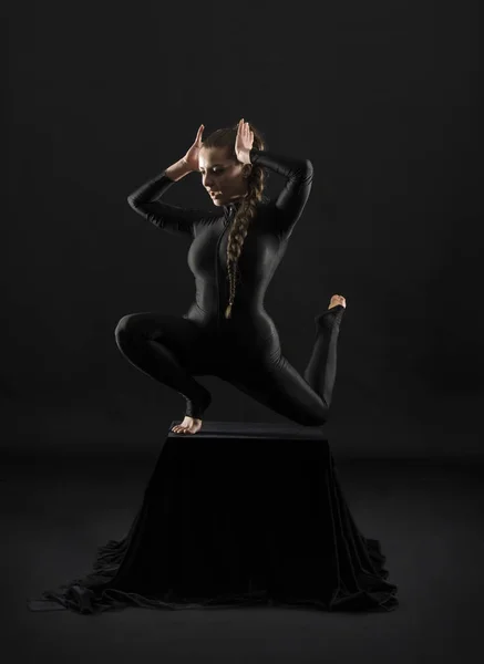 Девушка Черном Костюме Длинными Волосами Выполняет Гимнастические Упражнения Снимок Студии — стоковое фото