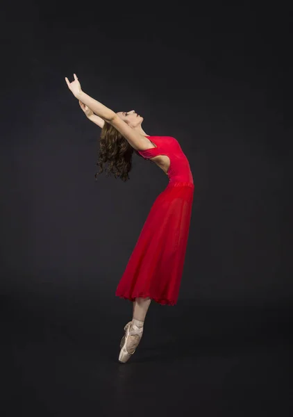 バレエを踊る赤での長い髪を持つ少女 暗い背景にスタジオ撮影 — ストック写真