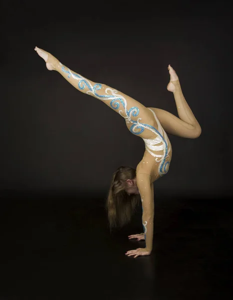 Молода Усміхнена Дівчина Костюмі Виконує Гімнастичні Вправи Студійні Зйомки Темному — стокове фото