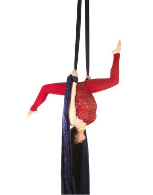 Kırmızı elbiseli uzun saçlı genç bir kız jimnastik gerçekleştirir ve sirk ipek egzersizleri.