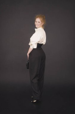 Beyaz bluz lu ve koyu pantolonlu kızıl saçlı kız.