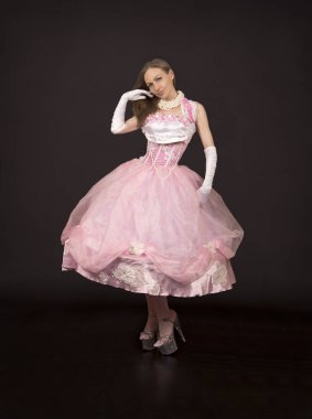 Karanlık bir arka plan üzerinde sahne kostümü giymiş bir kadının vurulması.