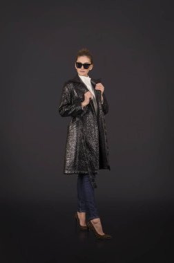 Sahte deri ve kot poz siyah pelerinli bir kız.