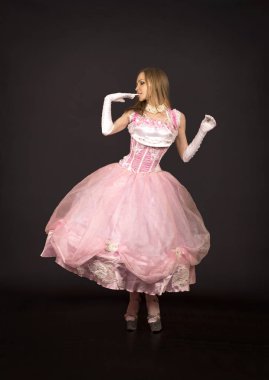 Karanlık bir arka plan üzerinde sahne kostümü giymiş bir kadının vurulması.