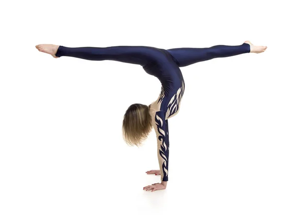 Girl gymnast, in a blue and white suit, engaged in acrobatics. — Stock Photo, Image