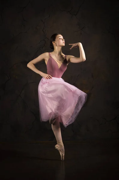 Una chica delgada con una falda rosa y un ballet beige bailando . —  Fotos de Stock