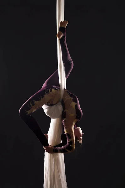 Αθλητικό κορίτσι σε ένα Μπορντώ κοστούμι εκτελεί ασκήσεις γυμναστικής και τσίρκου σε λευκό μετάξι, στο φανάρι. — Φωτογραφία Αρχείου
