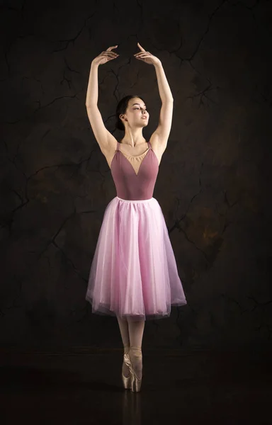 Uma menina esbelta em uma saia rosa e bege top dança balé . — Fotografia de Stock