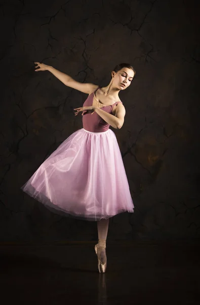 Une fille élancée dans une jupe rose et un ballet de danse beige . — Photo