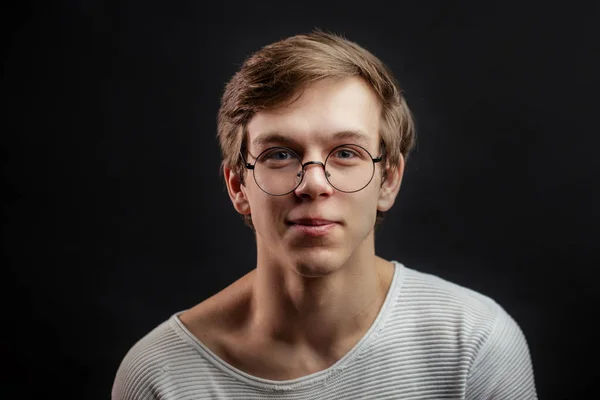 Portrait rapproché de ténager masculin dans des lunettes isolées sur le fond noir — Photo