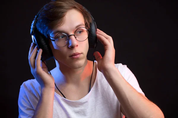 Portrait en gros plan d'un jeune homme aux cheveux blonds écoutant la musique — Photo