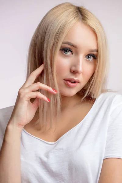 Nahaufnahme Porträt eines wunderschönen blonden Models mit grauen Augen, die ihr Haar berühren — Stockfoto