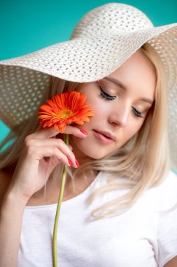 güzel sarışın Bayan şapka ile turuncu yakın çekim portre çiçek el