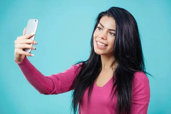 Atractiva mujer con el pelo negro usando su smartphone para selfie — Foto de Stock
