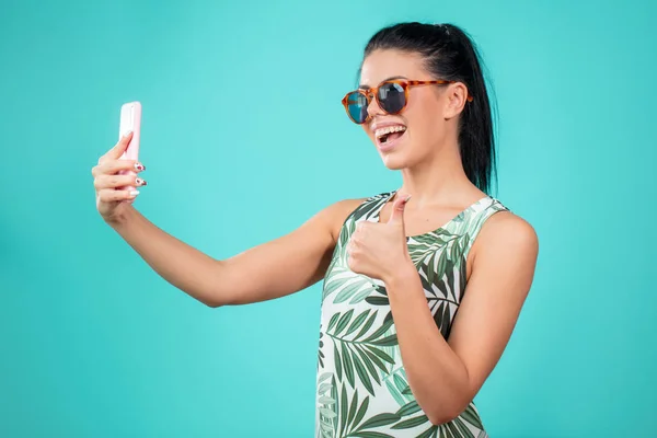 Sonriente atractiva mujer tomando un selfie aislado en el fondo azul — Foto de Stock