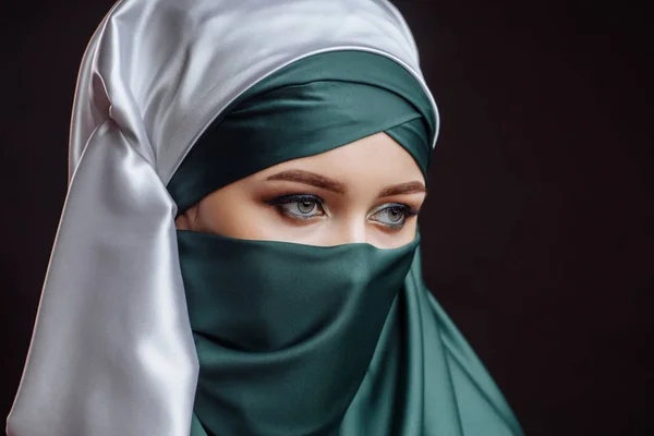 Närbild av side se sköt. en vacker dam är klädd i grön hijab — Stockfoto