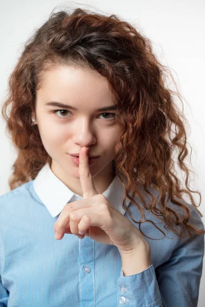 Gros plan de sourire belle adolescente rousse avec un doigt sur la bouche — Photo