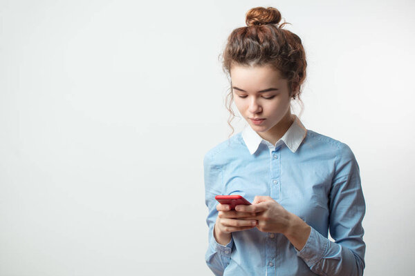 Портрет привлекательной молодой белой женщины с помощью мобильного телефона
