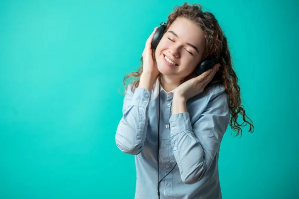 Close-up van portret van lachende gember meisje genieten van het lied in de koptelefoon — Stockfoto