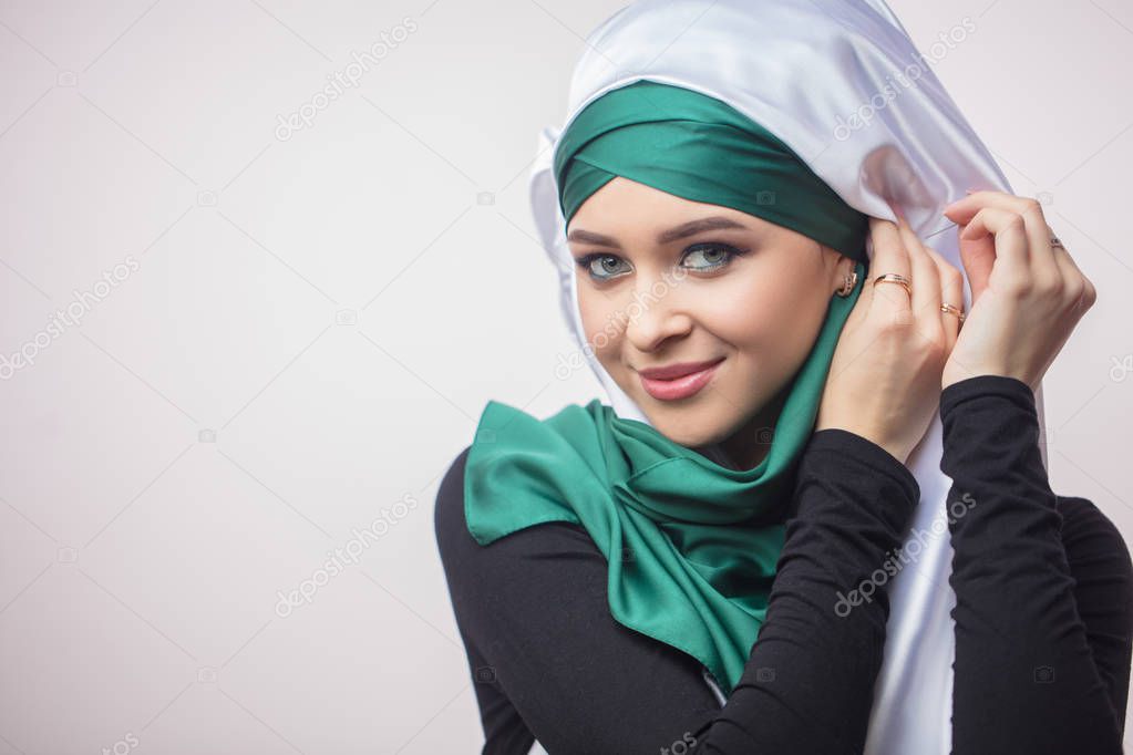 close up portrait od beautiful Muslim girl showing how to tie a headscarf