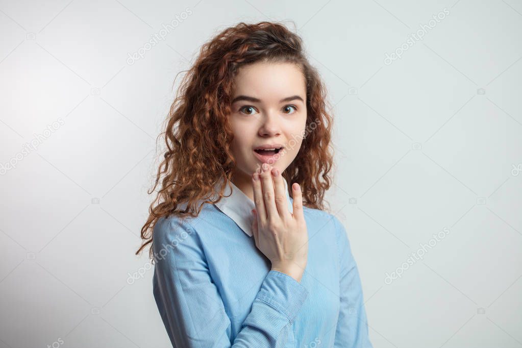 close up portrait of surprised attractive girl with red curly hair.