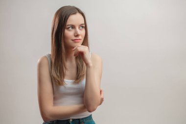 Çene üzerinde el ile sevimli genç kadın bir planı yapma