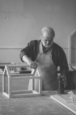 Matkap çalışırken kullanmak olacak beyaz saçlı yaşlı adam